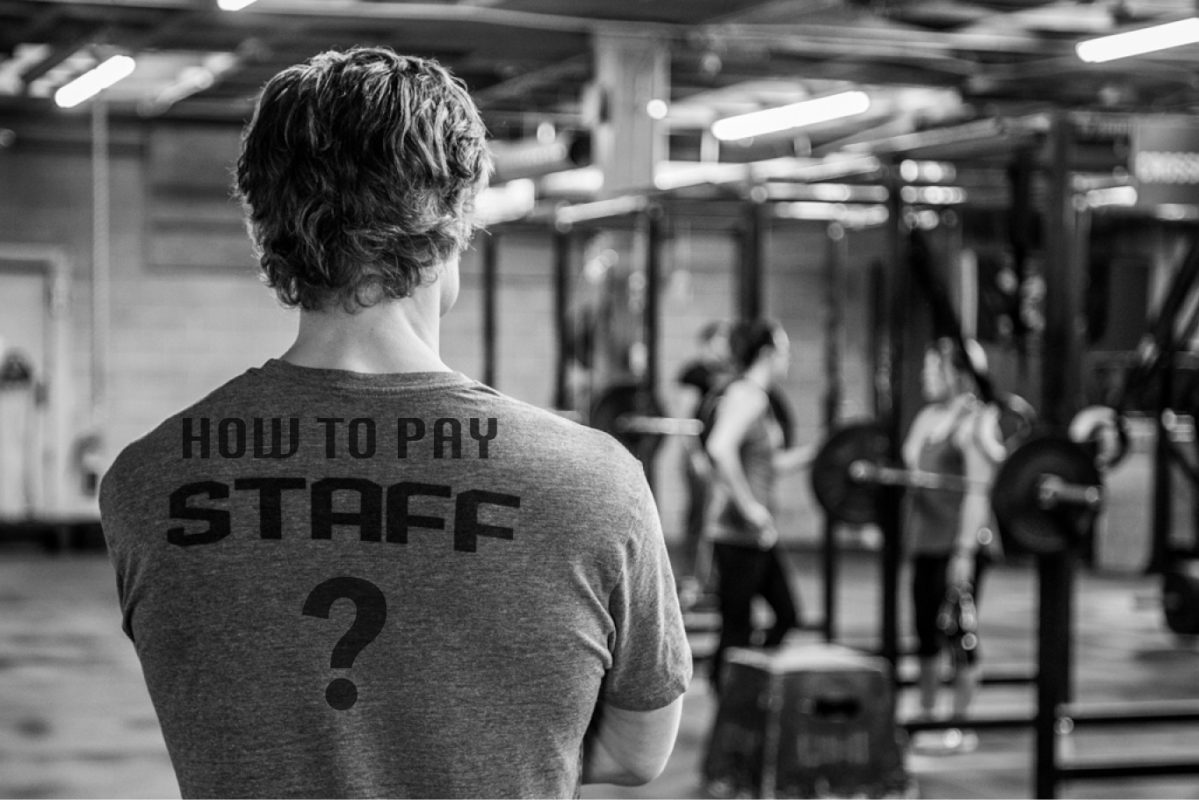 A black and white photo of a coach with the words "how to pay staff" written on the back of his shirt.