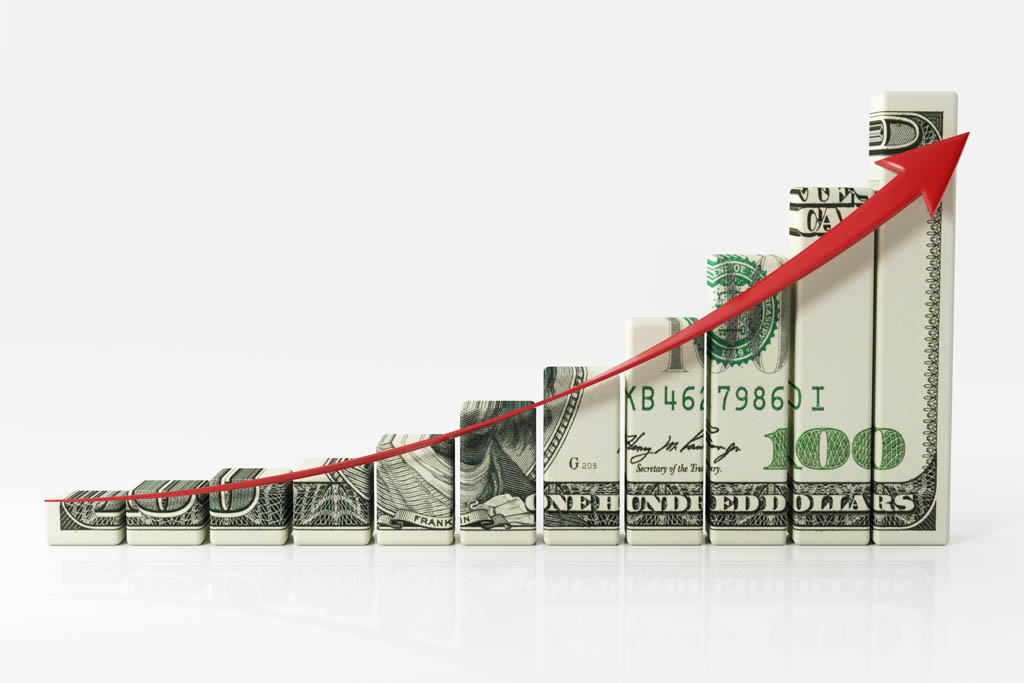 A sweeping red arrow arcs upward along an American dollar bill that has been chopped up to look like a bar graph.