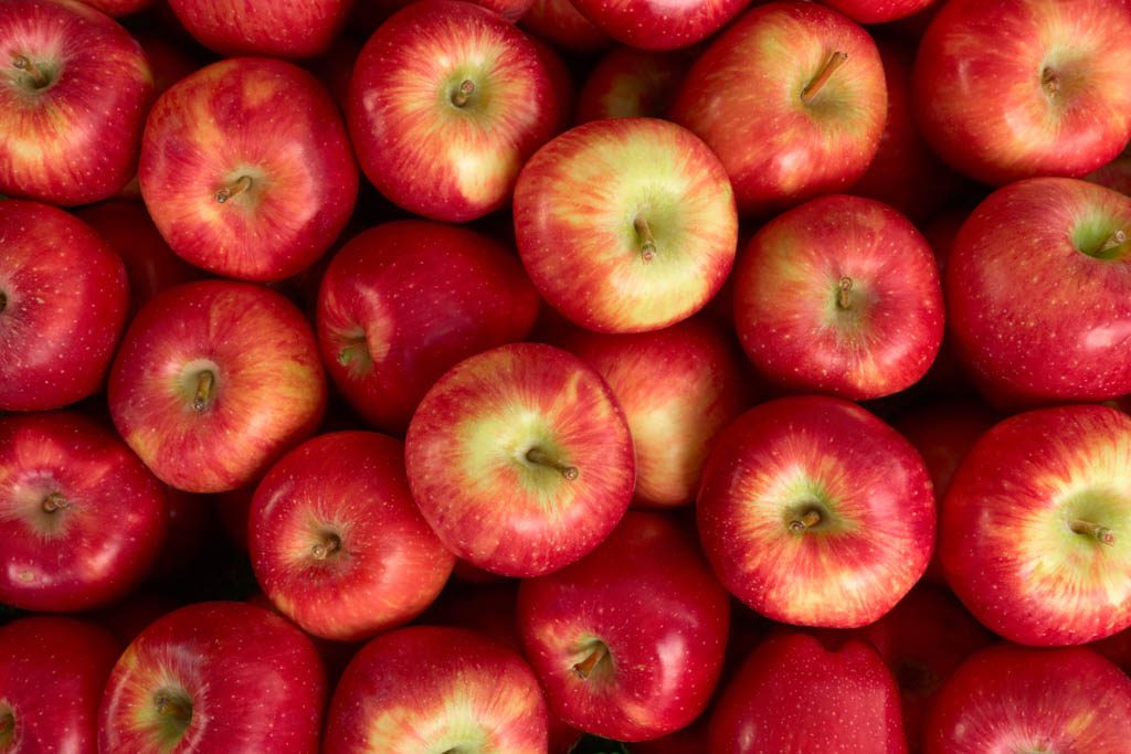 A large number of bright red apples piled together.
