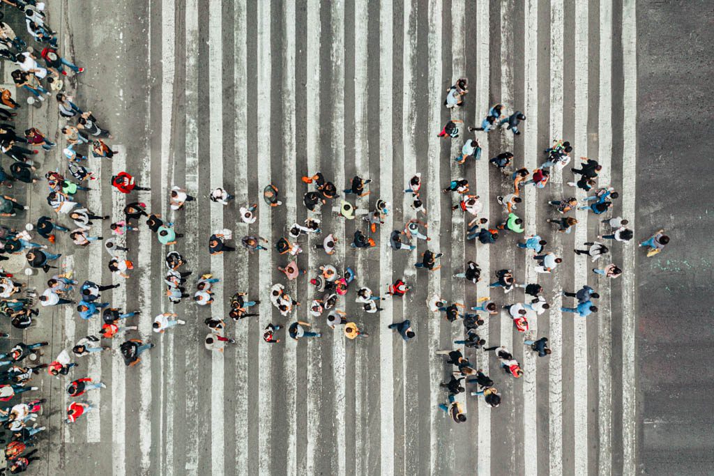 A high-angle view of people forming an arrow on the street.