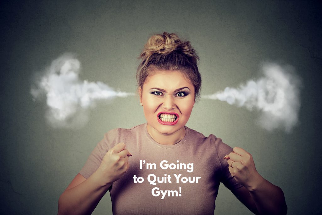 A very angry woman with clenched fists and steam coming out of her ears. Her shirt says, "I'm going to quit your gym."