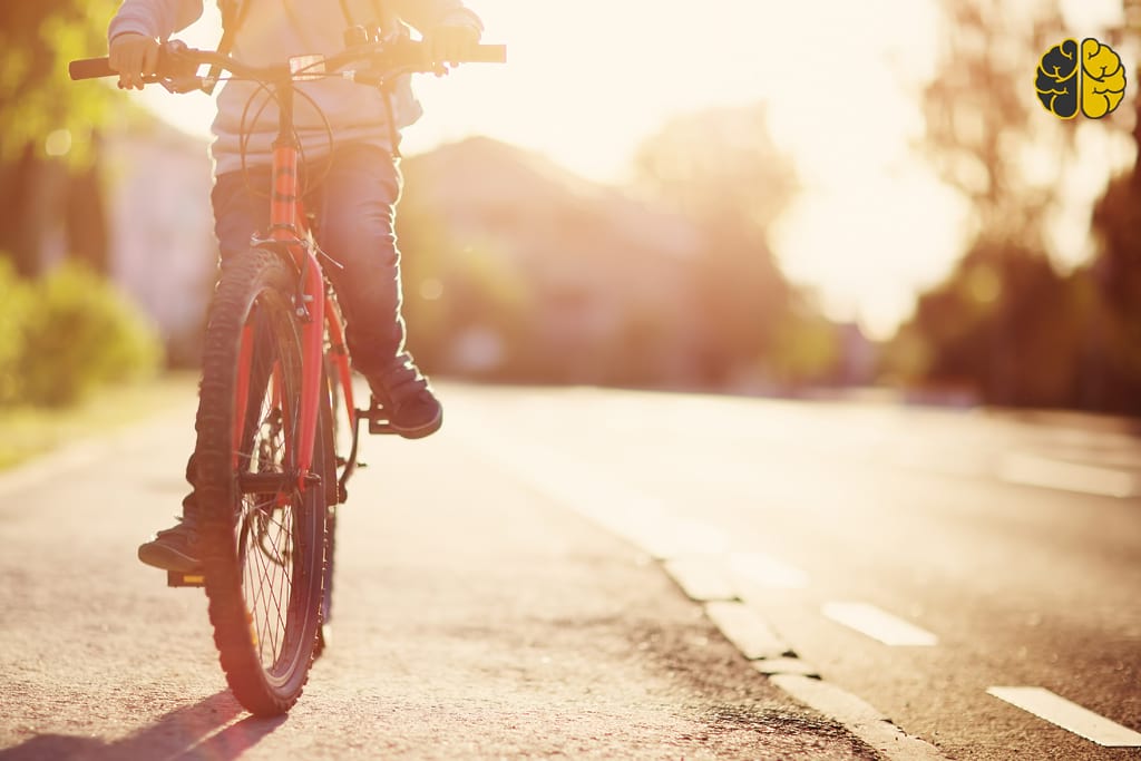 A kid riding a bike at sunrise
