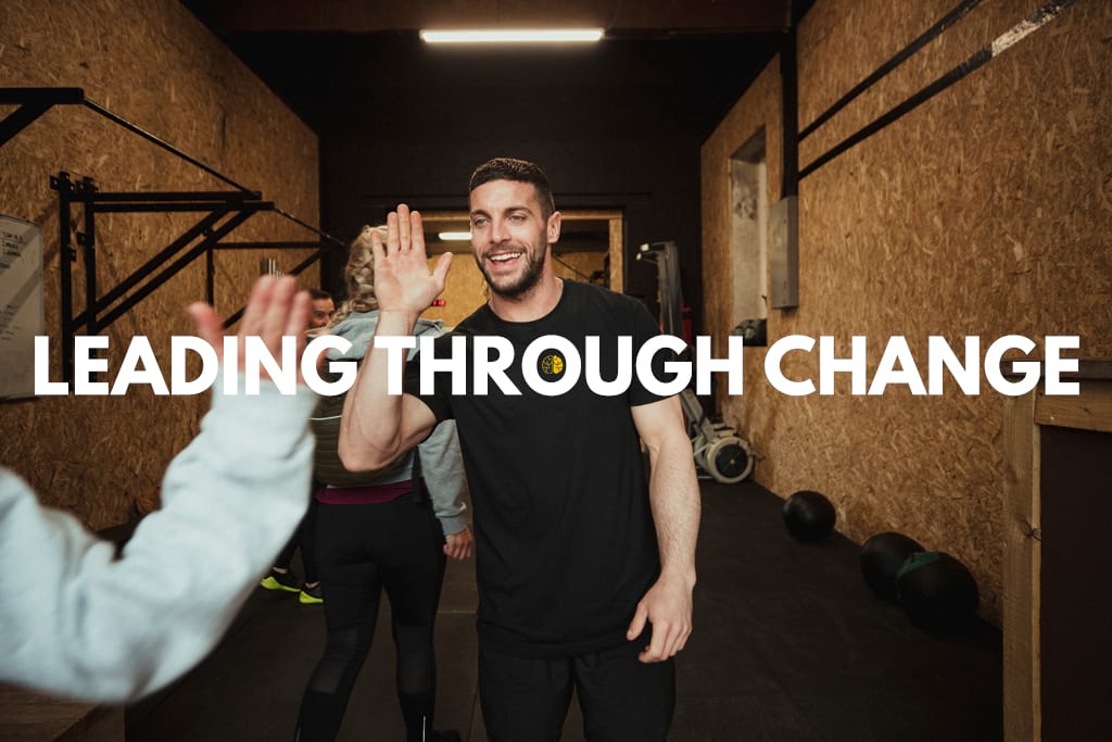 Leading through change - a coach high-fiving a member in a gym