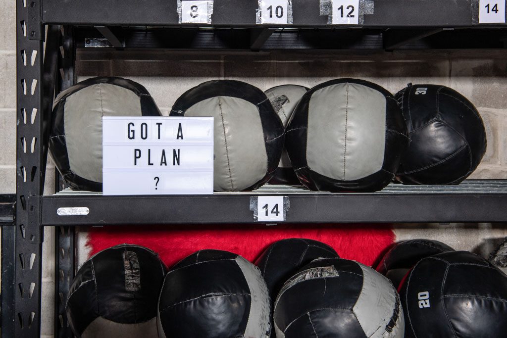 A stack of medicine balls with a sign that says "got a plan" to open with COVID restrictions?