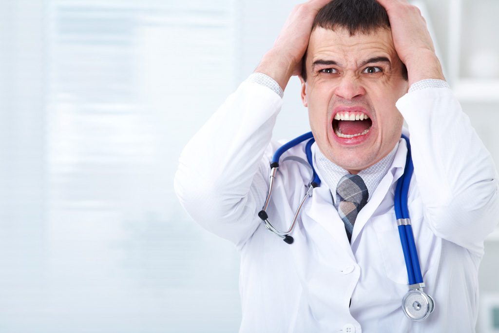 A stressed doctor puts his hands on his head and yells.