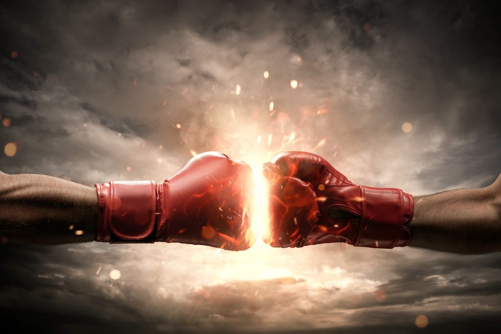 Two red boxing gloves come together and cause an explosion.