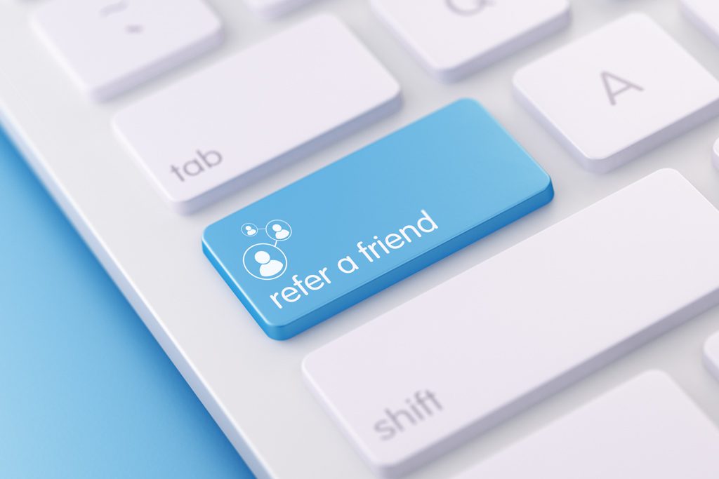 A bright blue keyboard button with the words "refer a friend."