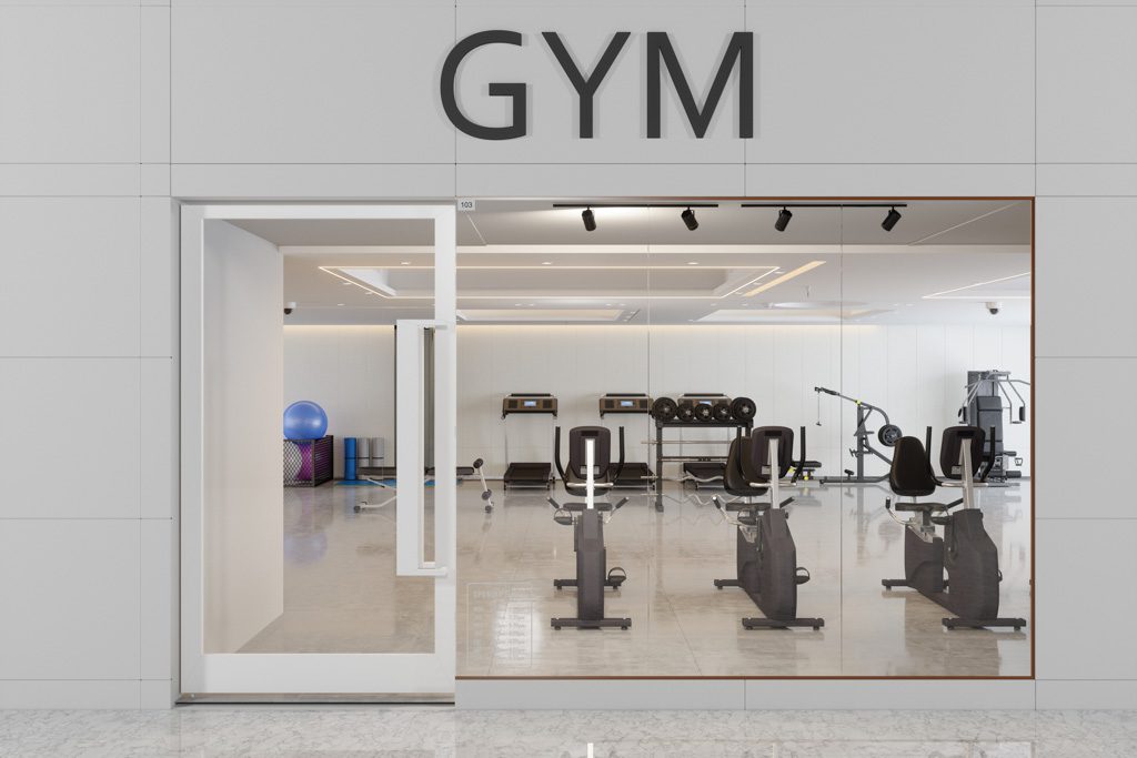 A photo of the storefront of a clean, organized gym with bikes and machines.