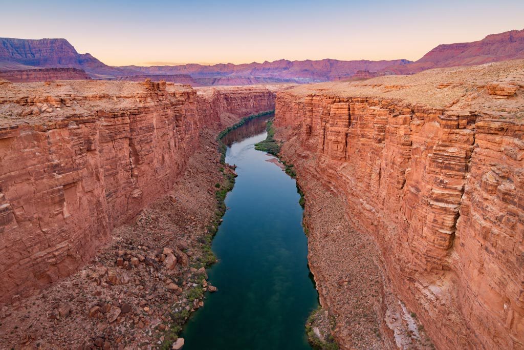 A panoramic shot of two cliffs with a river running between them.