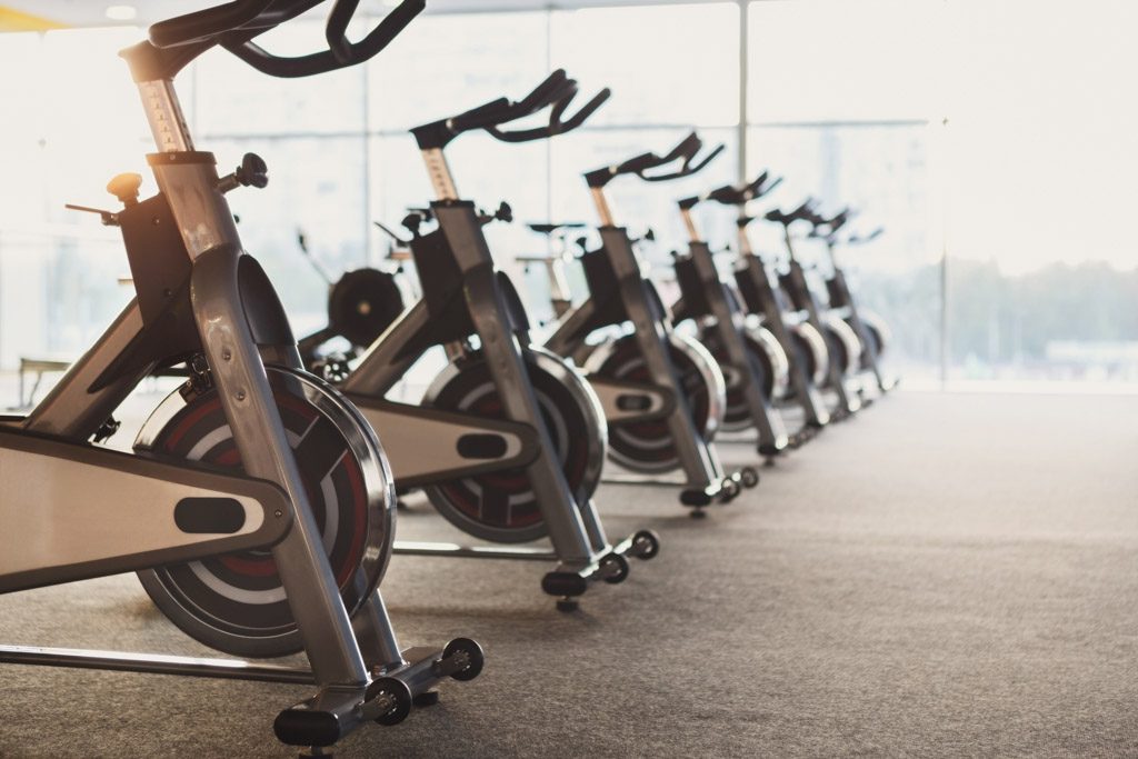 A row of expensive exercise bikes sitting in a gym.