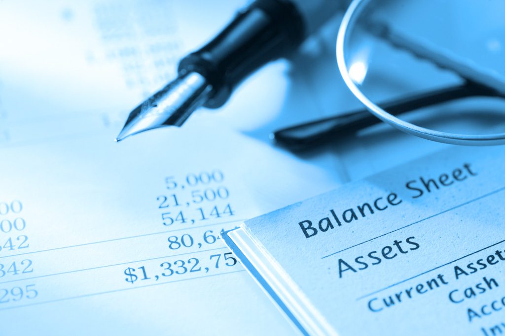 A closeup of a balance sheet and a pen.