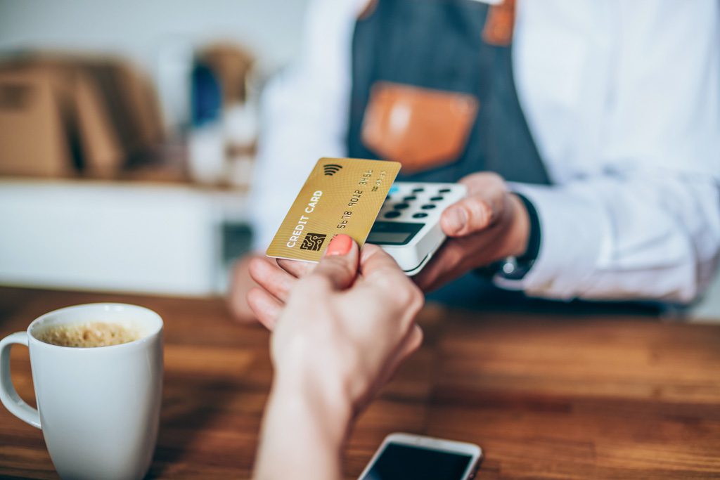 A new gym member uses a debit card to make a contactless payment at a gym.