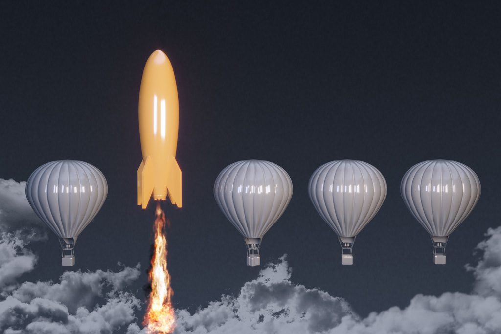 From a line of grey hot-air balloons a gold rocket ship flies upward.