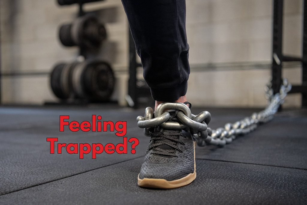 A gym owner's foot with a chain around it and the words "feeling trapped?"