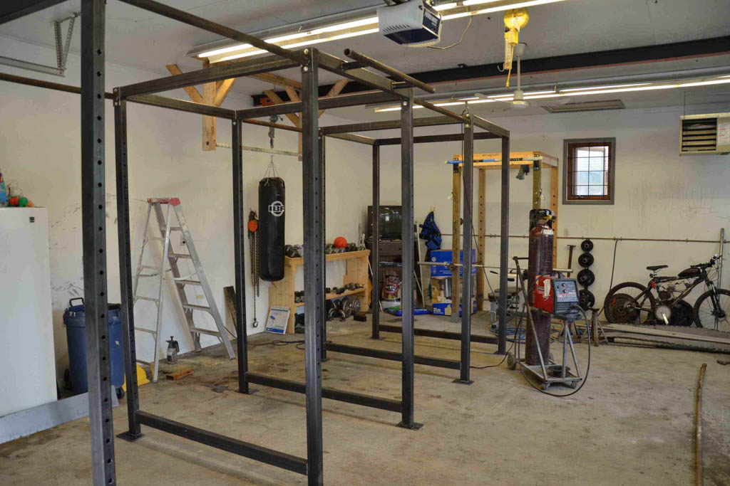 Welding equipment sitting next to a custom-built pull-up rig for a microgym.