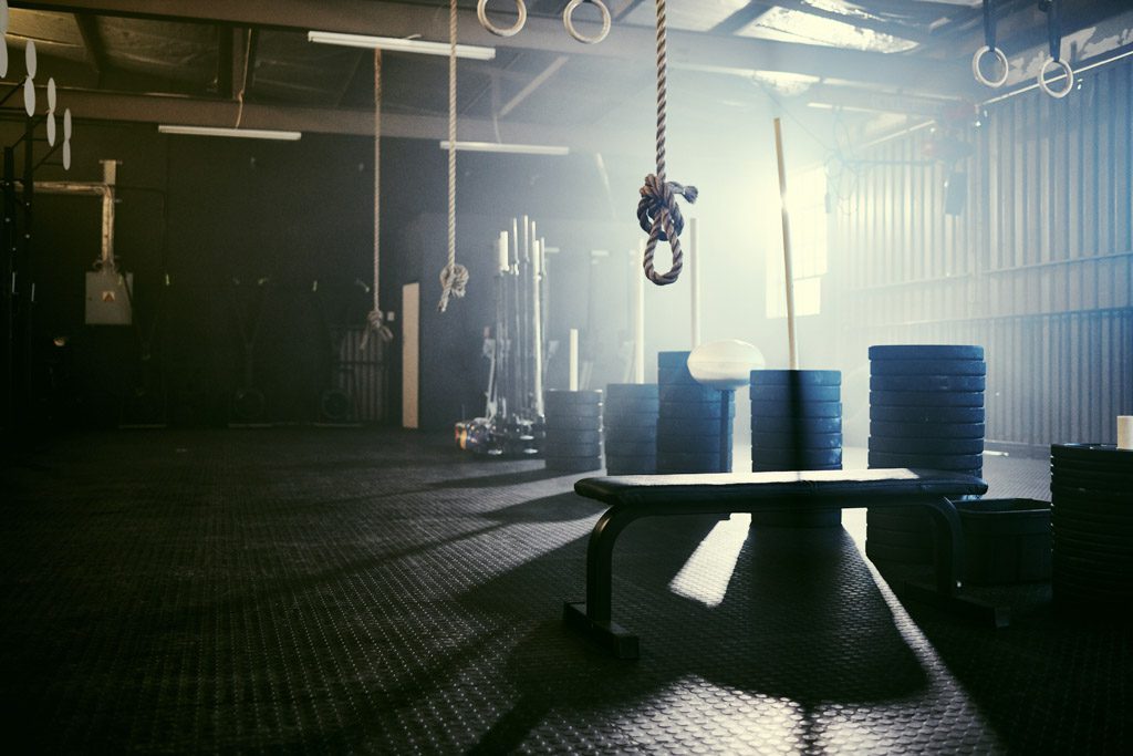 A photo of an empty functional fitness gym with light streaming in through a window.