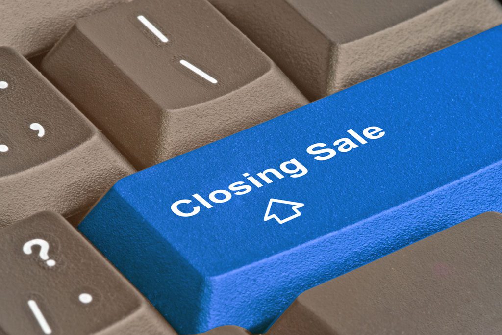 A closeup of a blue keyboard button that says "closing sale."