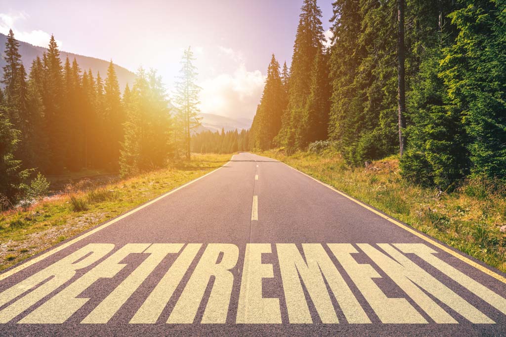 A road leading off into a forest with the word "retirement" written on it.