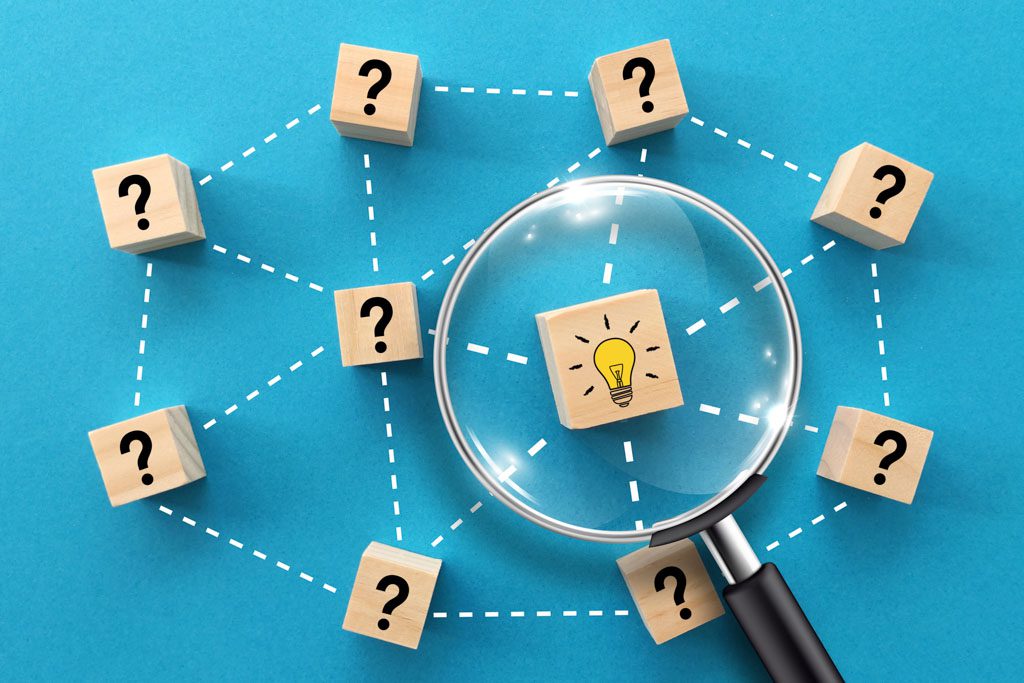 On a blue background, icons with question marks surround a magnifying glass focused on an icon with a light bulb.