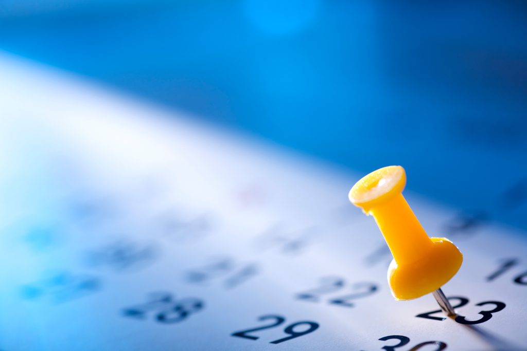 A bright yellow pin on a calendar marks the date of a special fitness competition.