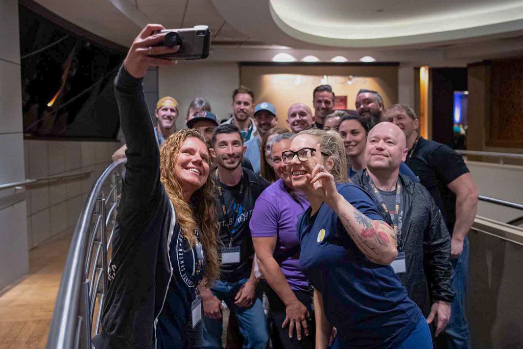 A group of happy clients take a selfie with mentor Anastasia Bennett at the 2022 Two-Brain Summit.