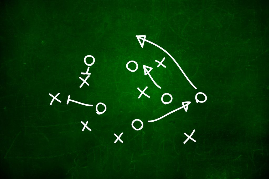 On a green background, a football play is diagrammed with white X's and O's.