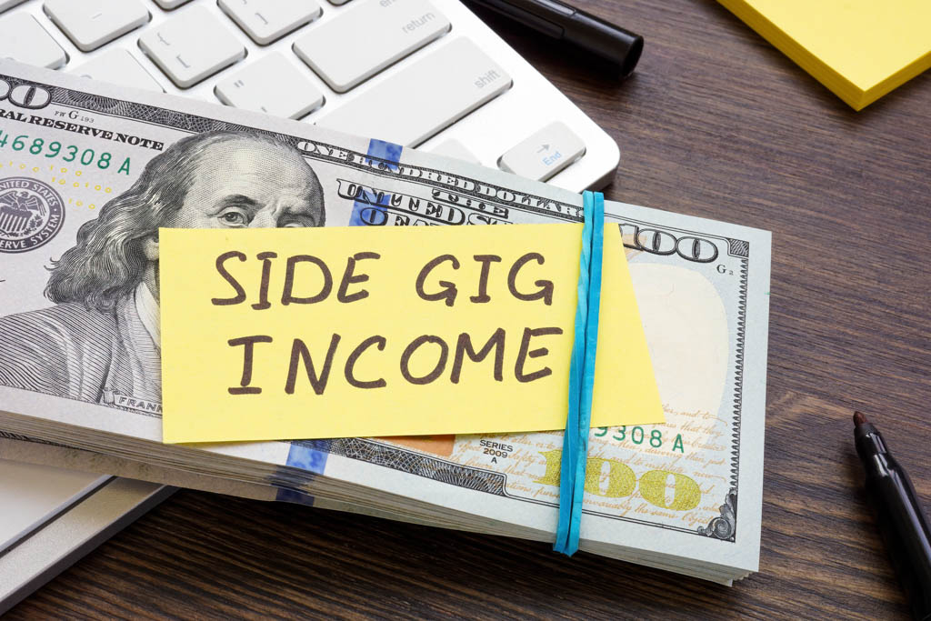 A sticky note on a stack of money reads "side gig income."