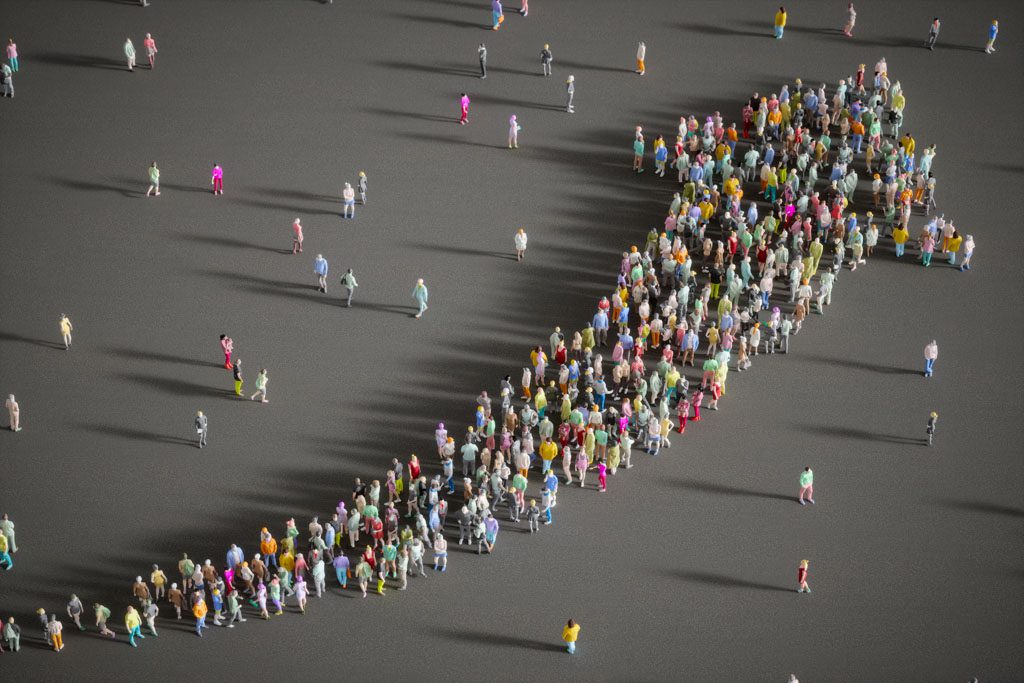 A huge crowd of people standing in the shape of an arrow pointing up.