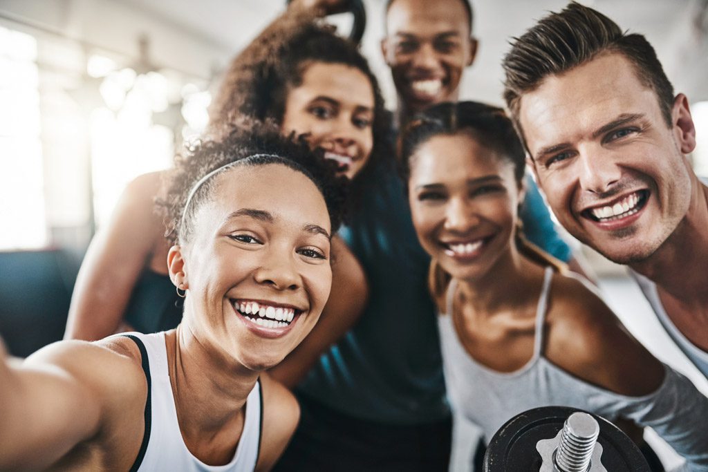 A shot of a group of happy people taking a selfie together during their workout in a gym.