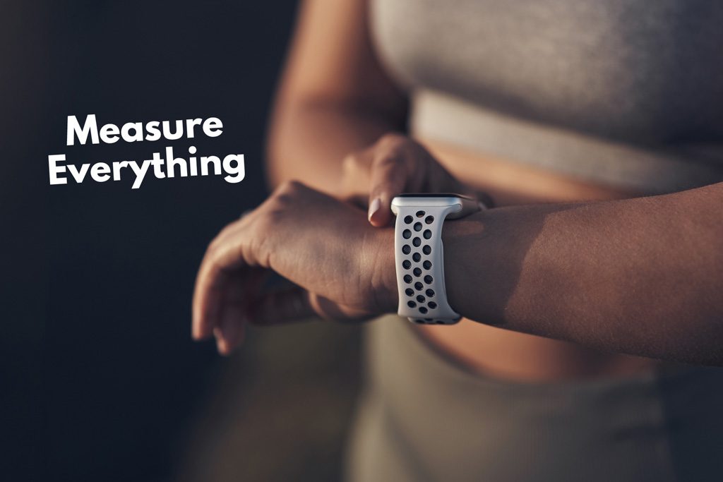 A gym owner checks her smartwatch with the caption "measure everything."