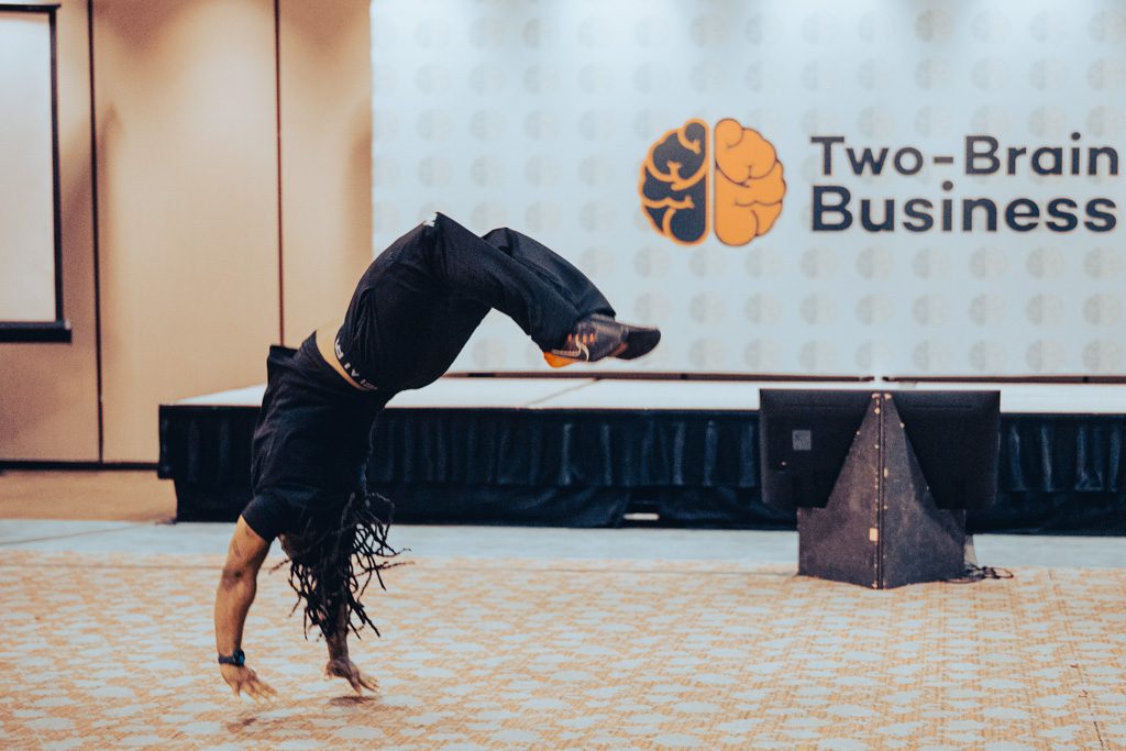 A gym owner performs a back handspring at the Two-Brain Summit.