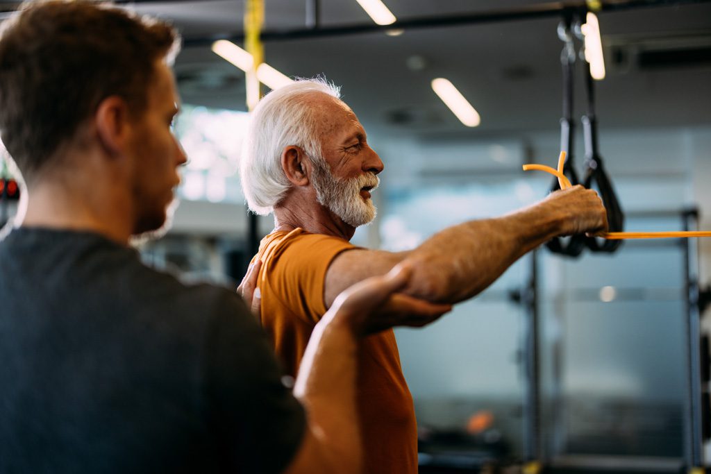A personal trainer works one on one with an older client.