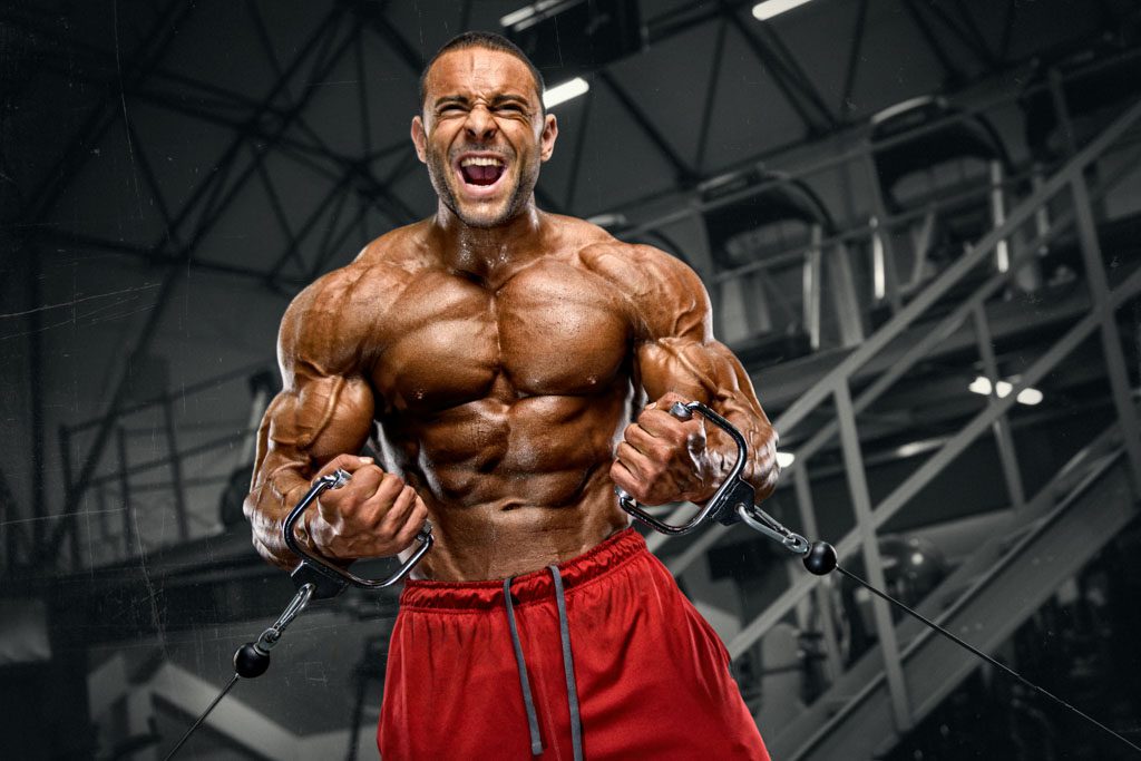 A huge bodybuilder performs cable cross-overs.