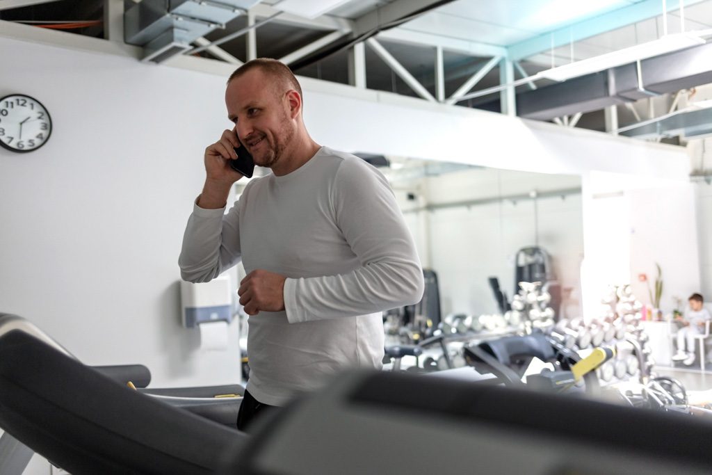 A gym owner picks up the phone to call a new lead.