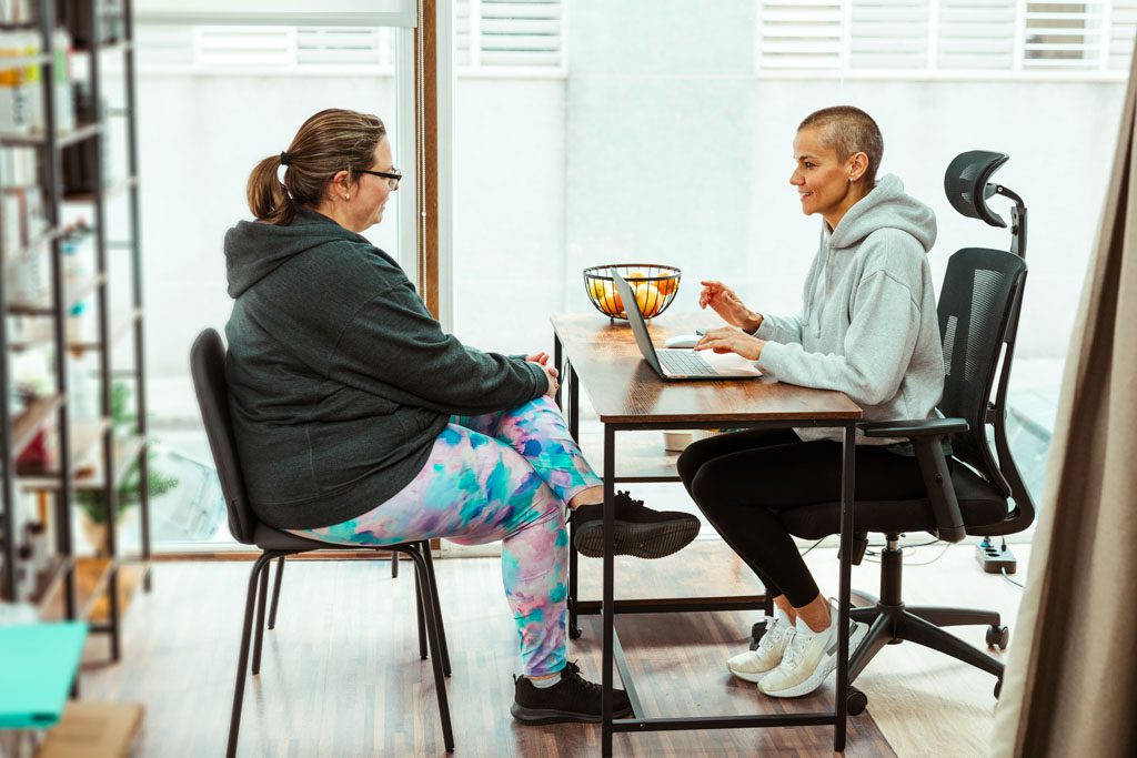 A gym owner meets with a client to do a Goal Review Session
