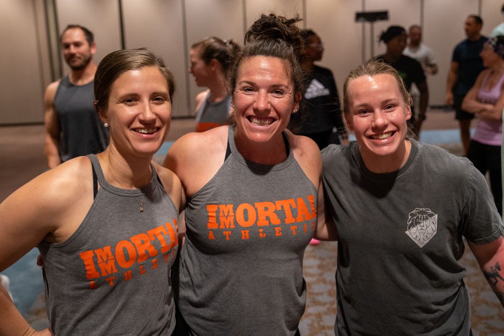 Tori Jablonka smiles as she poses with two friends at the Two-Brain Summit.