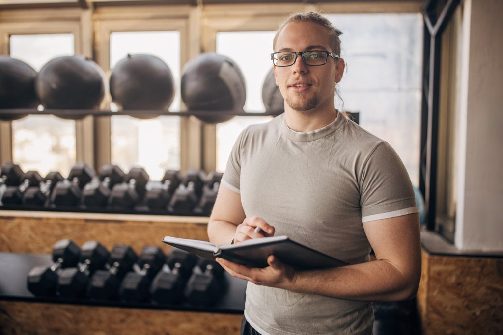 A gym owner reviews metrics in a notebook.