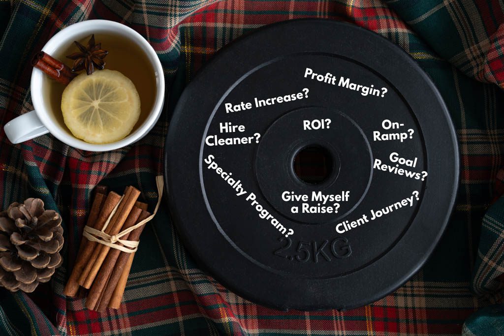 A black bumper plate sits on a table next to fall themed beverages.