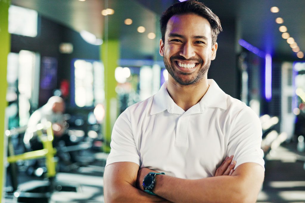 A smiling gym owner stands in his training space.