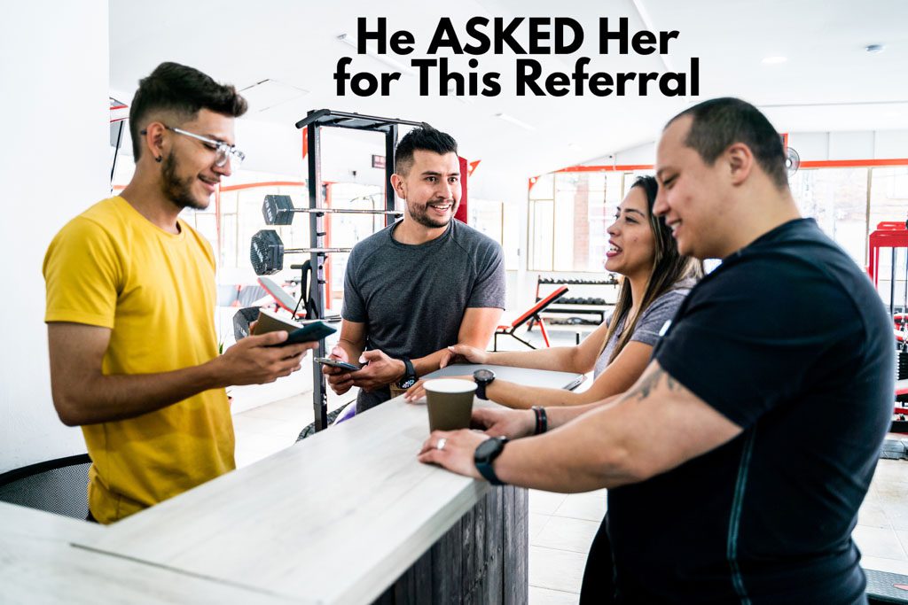 A photo of a gym owner welcoming a referred client into the gym.