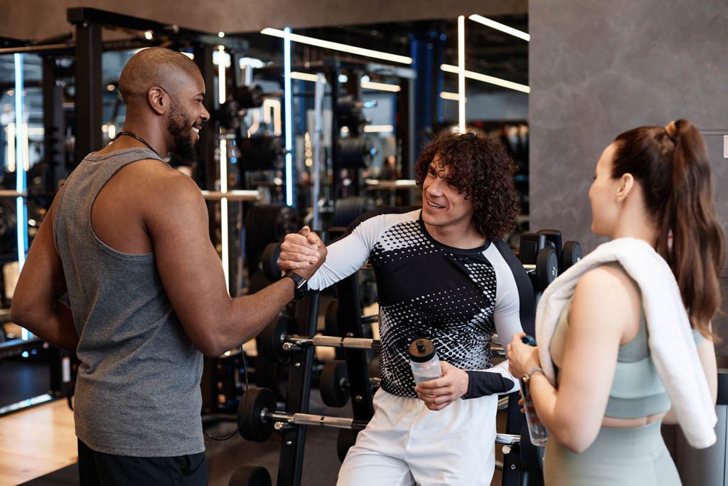 A photo of a gym owner welcoming a referred client into the gym.