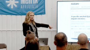 Emily Kaplan of MetFix lecturing in a gym.