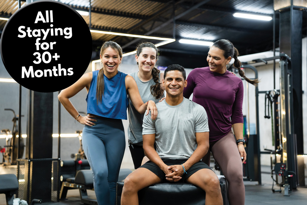 A group of clients sit in a gym, with a caption that reads "all staying for 30+ months."