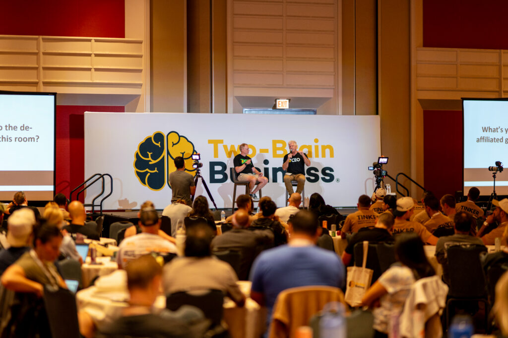 Two-Brain founder Chris Cooper and CrossFit CEO Bruce Edwards on-stage in front of crowd at the Two-Brain Summit